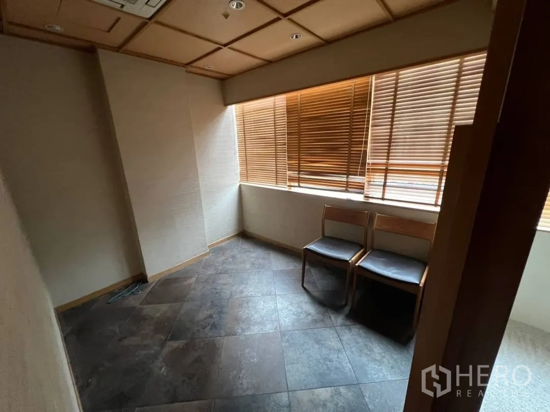 พื้นที่ขายปลีก ให้เช่า - ห้องขนาดกะทัดรัด ปูกระเบื้องลายหิน มีหน้าต่างมุมและม่านไม้บังตา