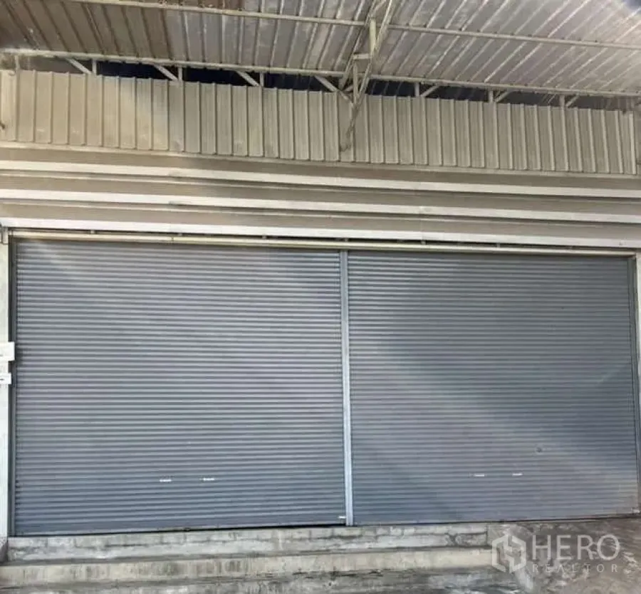 คลังสินค้า ให้เช่าในBang Khae, Bangkok - ด้านหน้าโกดัง ประตูม้วนเหล็กบานกว้าง พร้อมกันสาดสำหรับโหลดสินค้า