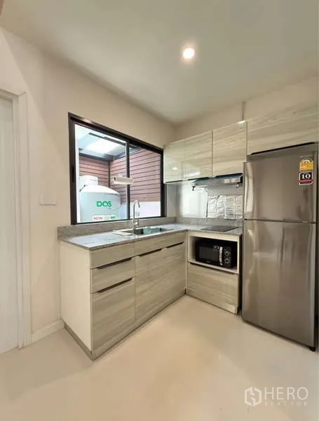 联排别墅 出租在Bang Phli, Samut Prakan - 紧凑L形厨房，窗户、水槽、微波炉与冰箱。