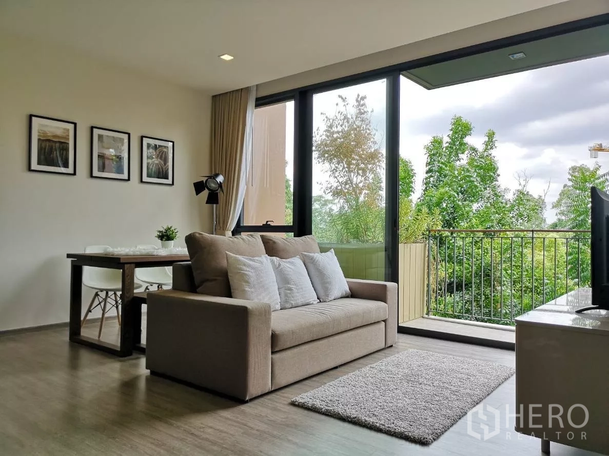 คอนโด ให้เช่าในWatthana, Bangkok - ห้องนั่งเล่นสว่าง โซฟาและโต๊ะทานข้าว เปิดสู่ระเบียงพร้อมวิวสวนเขียว