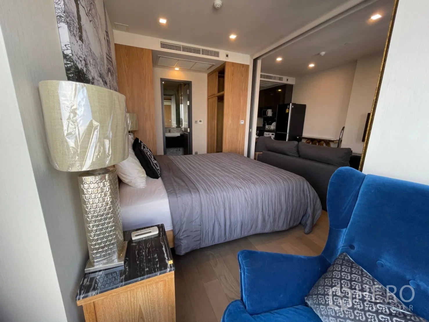 公寓 for rent in Watthana, Bangkok - 卧室一角有软椅、床头灯与临窗景观。