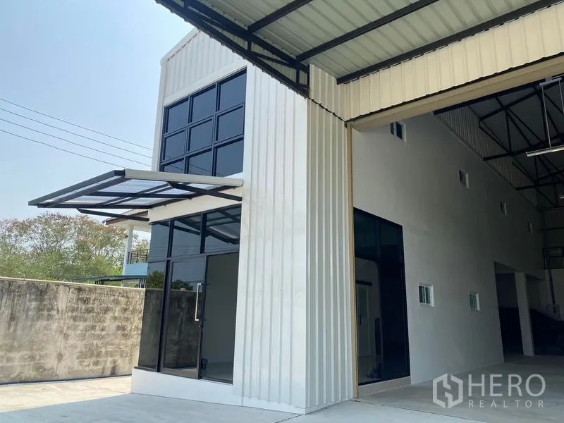 คลังสินค้า ให้เช่าในBang Kruai, Nonthaburi - ด้านหน้าอาคารโกดังสมัยใหม่ ประตูกระจกและประตูม้วนขนาดใหญ่