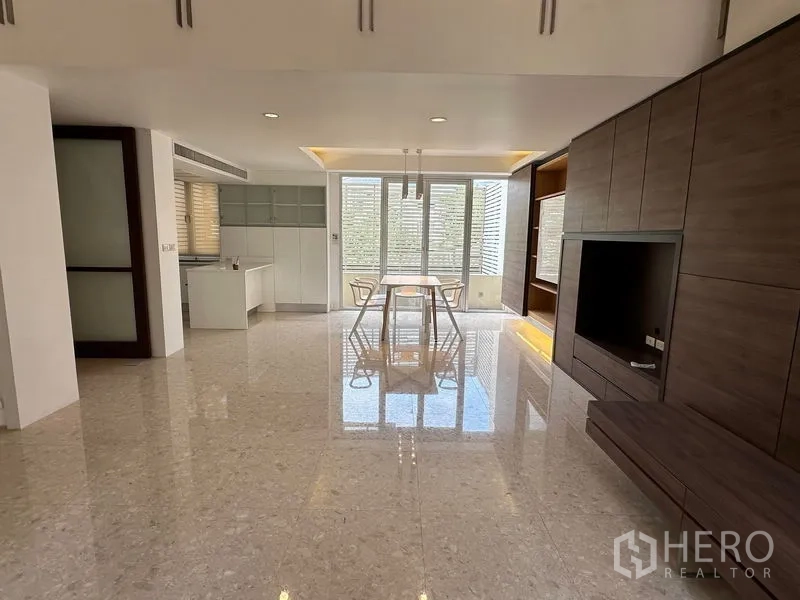 Townhouse for sale in Yan Nawa, Bangkok - Open-plan living and dining with glossy stone floors, built-in media wall and bright kitchen