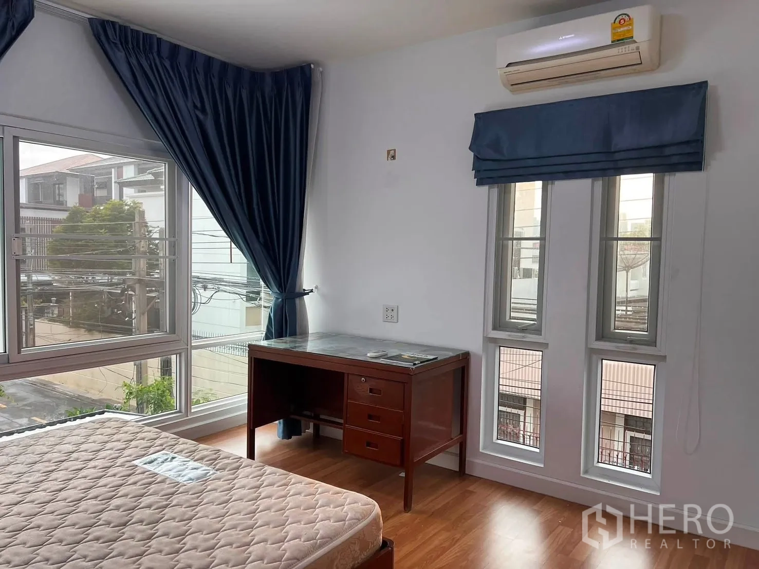 Detached House for rent in Watthana, Bangkok - Corner bedroom with large windows, desk, mattress, and air conditioner.