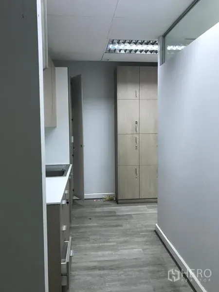 零售空间 出租在Pathum Wan, Bangkok - 服务走廊带储物柜与浅木色茶水间柜体。