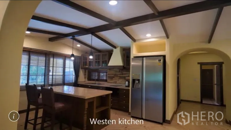 Detached House for rent or sale in Bang Phli, Samut Prakan - Western kitchen with island, stainless refrigerator, range hood and arched doorway.