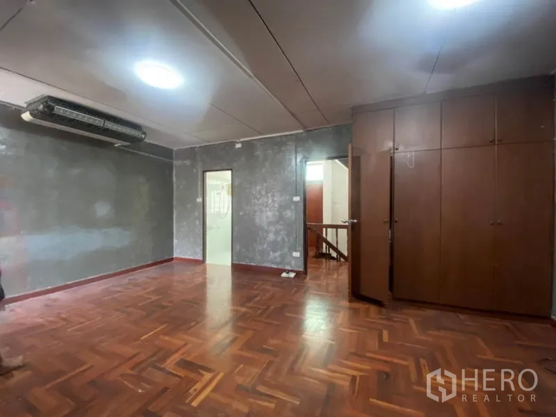 ทาวน์เฮาส์ ให้เช่าในWatthana, Bangkok - ห้องกว้างผนังปูนดิบเฉดเทา ตู้บิลท์อิน และพื้นไม้ปาร์เกต์.