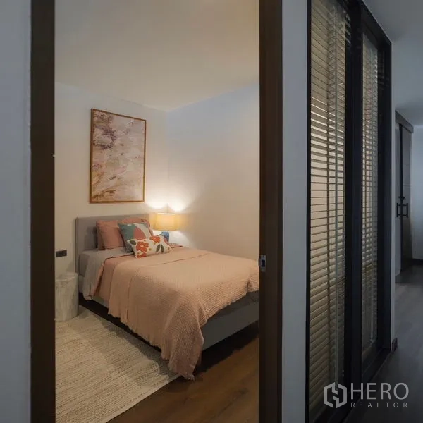 Townhouse for rent - Cozy guest bedroom with soft pink bedding and bedside lamp.