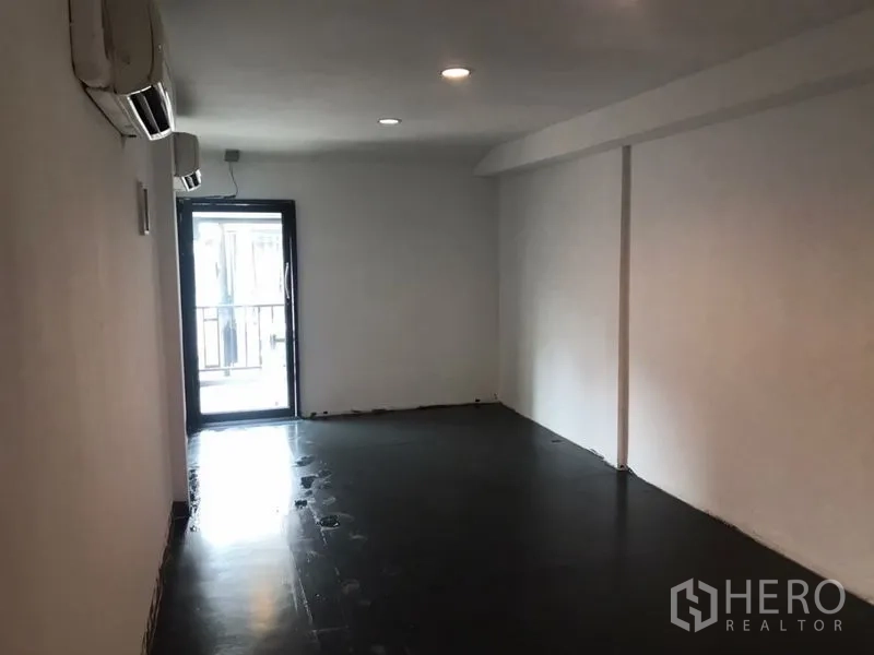 Home Office for rent or sale in Khlong Toei, Bangkok - Open room featuring two wall AC units and a glass door to the balcony.