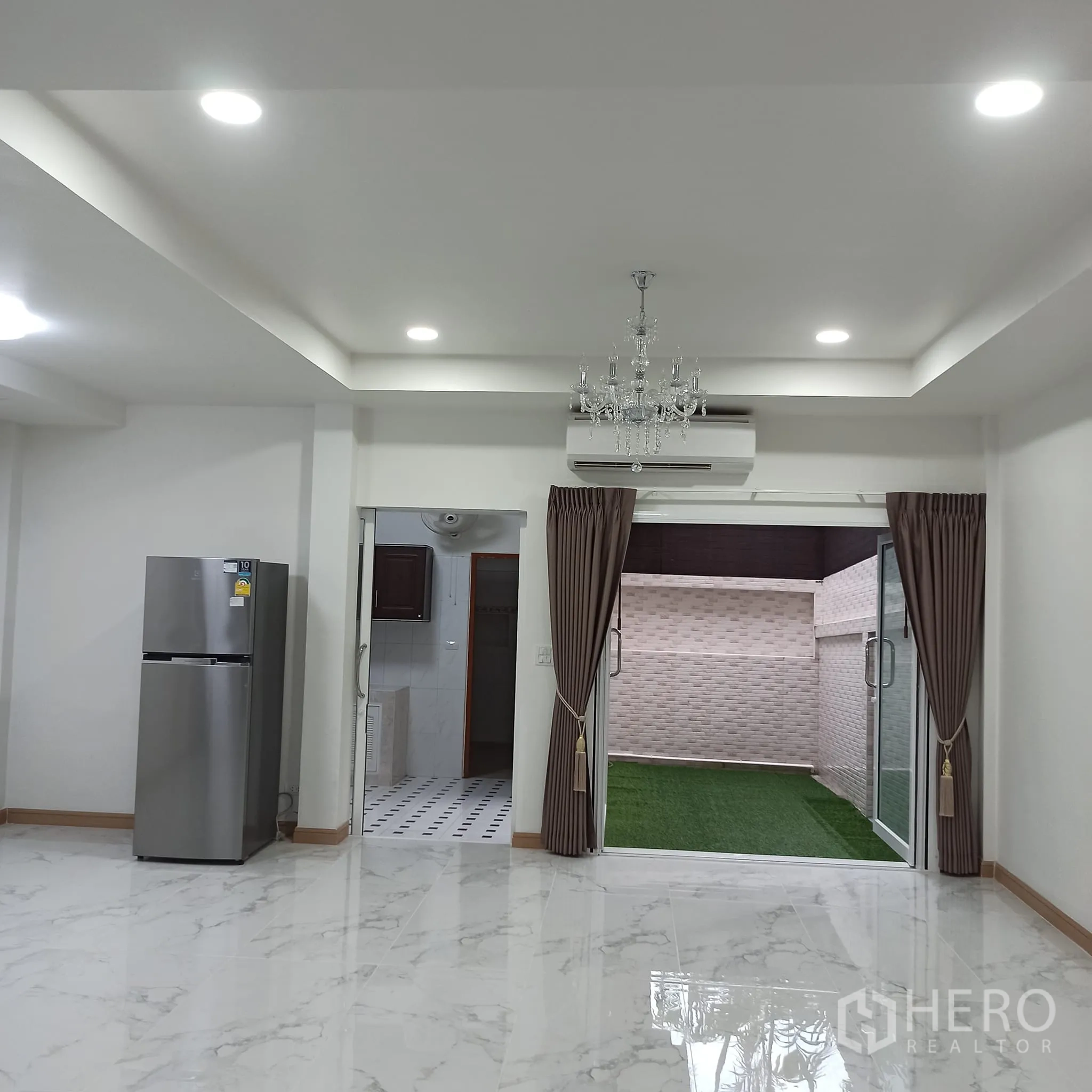 Townhouse for rent in Wang Thonglang, Bangkok - Spacious living-dining area with sliding doors to the garden patio.