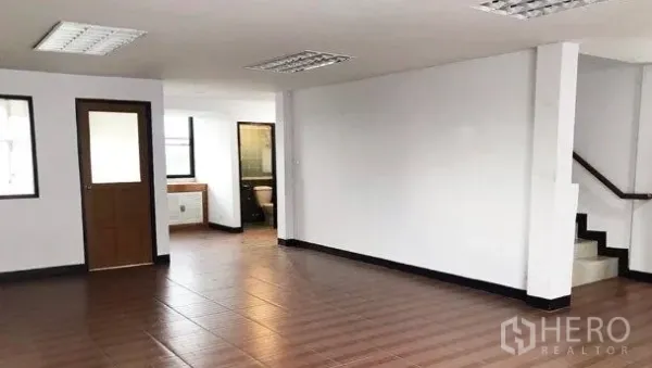 Office Space for rent or sale in Don Mueang, Bangkok - Open-plan level with brown tile floors, internal doors, stairway and a restroom area.
