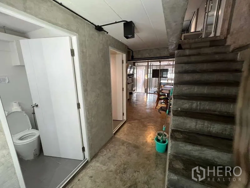 อาคารพาณิชย์ ขายในSuan Luang, Bangkok - โถงชั้นล่างมีห้องน้ำ บันไดคอนกรีต และพื้นที่ทำงานกระจกด้านหน้า