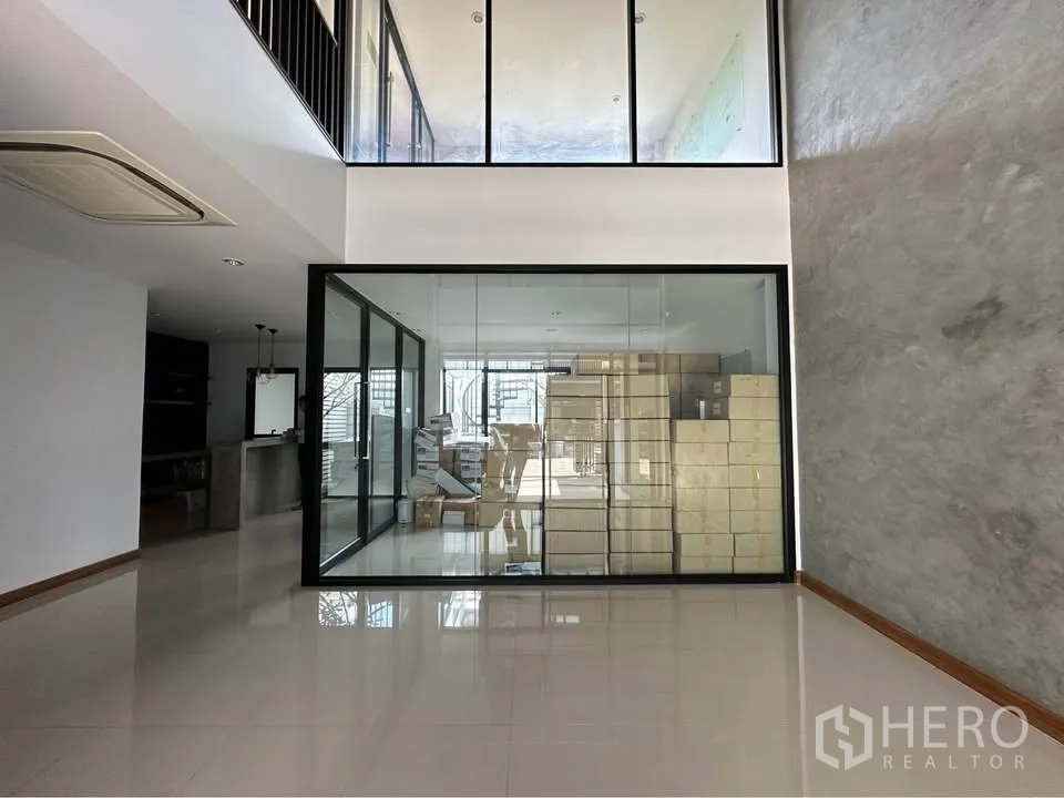 Townhouse for rent in Pak Kret, Nonthaburi - Covered parking bay with slatted gate and glass entry doors.