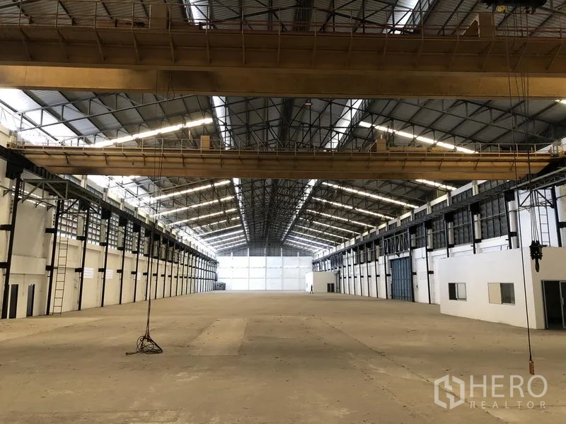 工厂 出租在Mueang Samut Prakan, Samut Prakan - 中轴视角，顶部多台行车，左右设办公室与装卸门。