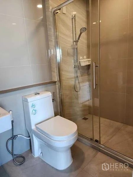 公寓 出租 - 现代浴室，玻璃淋浴间与坐便器。