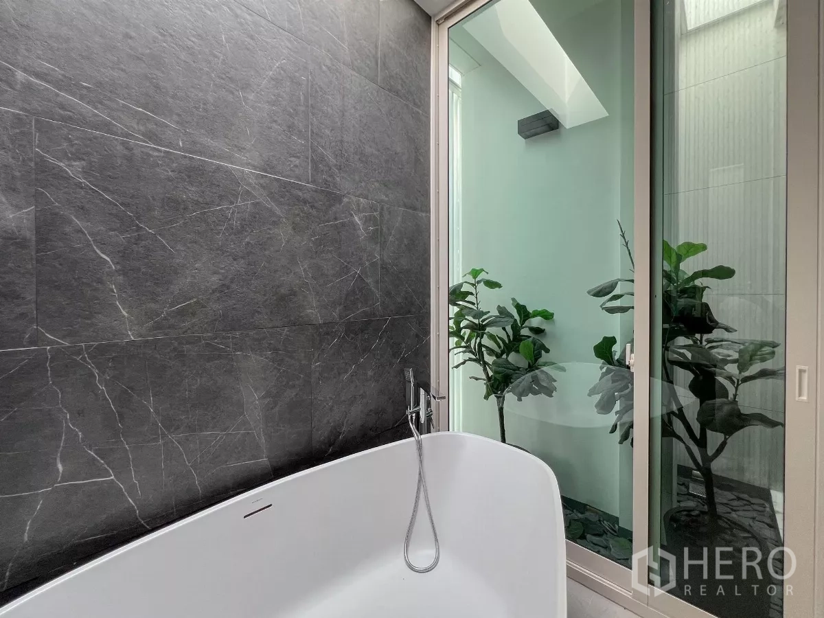 Detached House for sale in Bang Phli, Samut Prakan - Bathtub beside an indoor garden atrium with sliding glass door