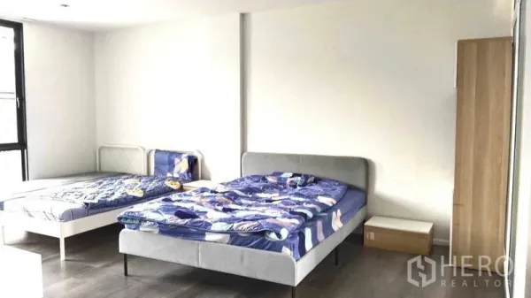 Home Office for rent - Bright bedroom with two beds, wardrobe and wood flooring.