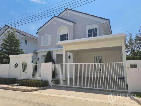 Detached House for rent in Bang Phli, Samut Prakan - Two-storey detached house exterior with gated carport and white fence on a sunny day