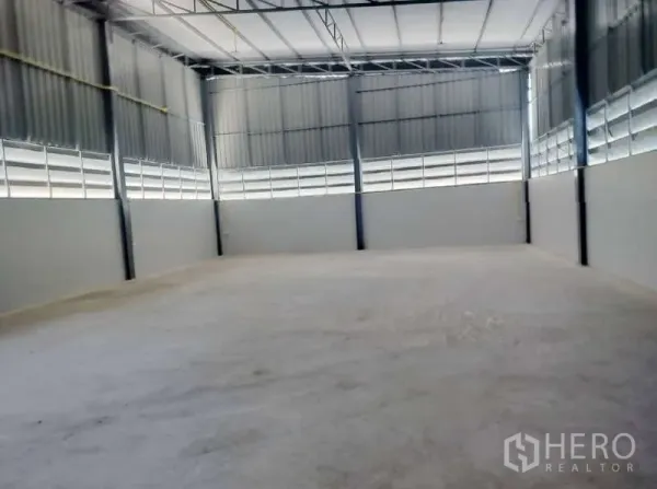 Warehouse for rent in Pathum Thani - Spacious warehouse interior with high ceiling, steel beams and smooth concrete floor.