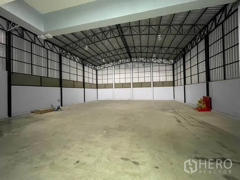 Warehouse for rent in Bang Kapi, Bangkok - High-clear warehouse interior with steel frame, lighting and polished concrete floor.