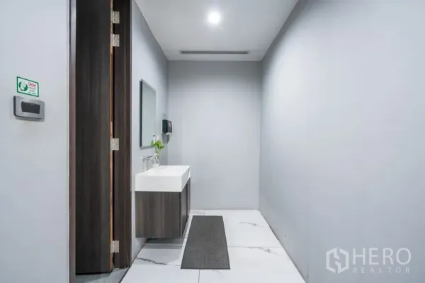 办公空间 出租 - 现代办公区洗手间走廊，壁挂式洗手台与镜面照明