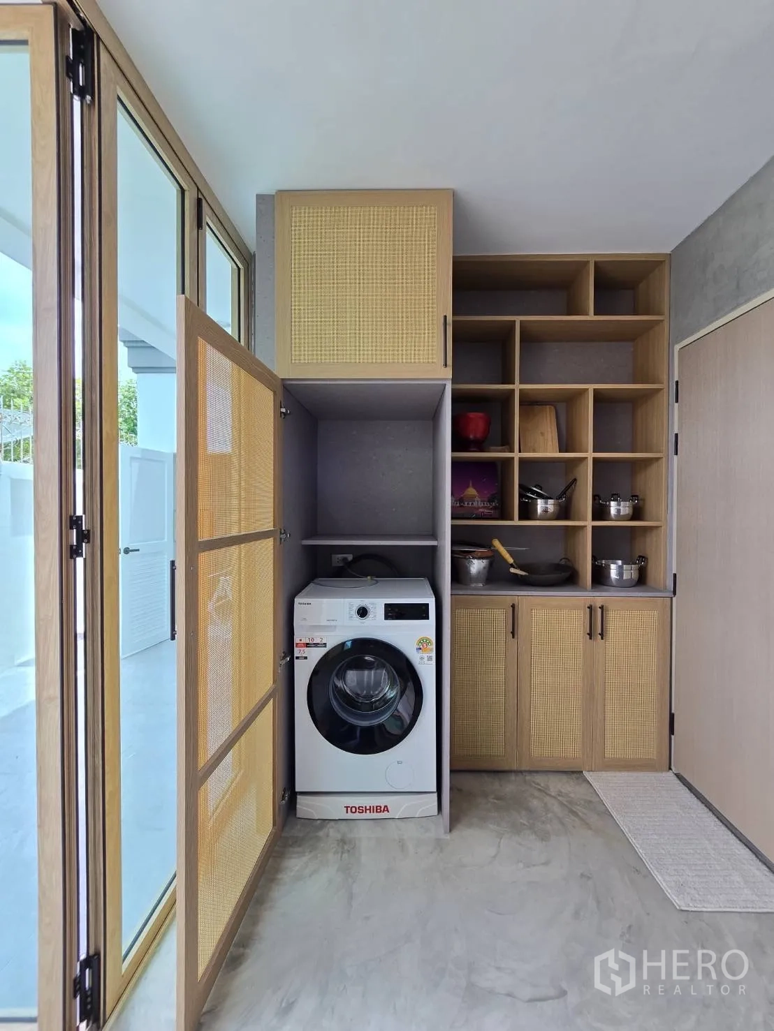 独立式住宅 出售在Suan Luang, Bangkok - 洗衣与收纳区，前置洗衣机与定制橱柜。