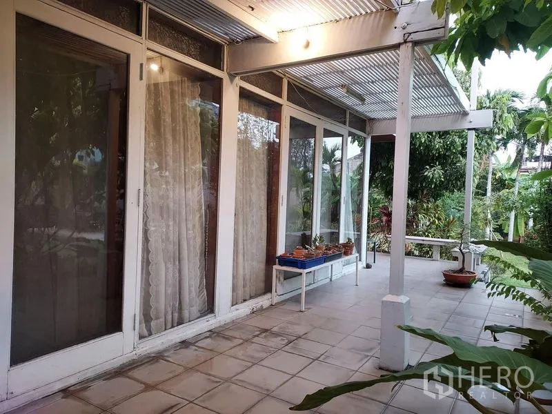 บ้าน ให้เช่าในMueang Samut Prakan, Samut Prakan - ลานหลังบ้าน ประตูกระจกกรอบสีขาว ใต้กันสาดลอน พร้อมสวน