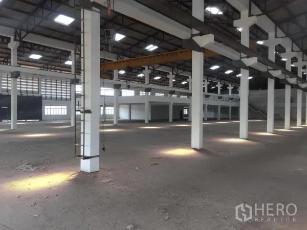 Warehouse for rent in Lam Luk Ka, Pathum Thani - Spacious warehouse interior featuring tall columns, a high steel roof with skylights, and an open floor suitable for storage or production.
