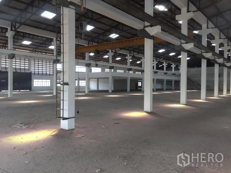 Warehouse for rent in Lam Luk Ka, Pathum Thani - Spacious warehouse interior featuring tall columns, a high steel roof with skylights, and an open floor suitable for storage or production.