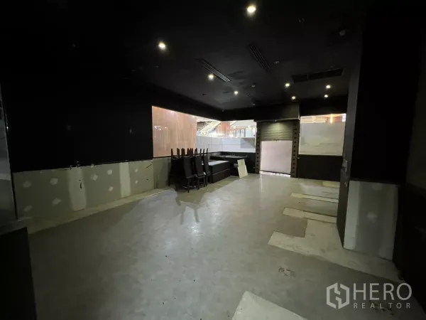 พื้นที่ขายปลีก ให้เช่า - โถงขายของหรือรับประทานอาหารเพดานสีดำ ไฟดาวน์ไลท์ ม้วนประตูและช่องกระจกขนาดใหญ่