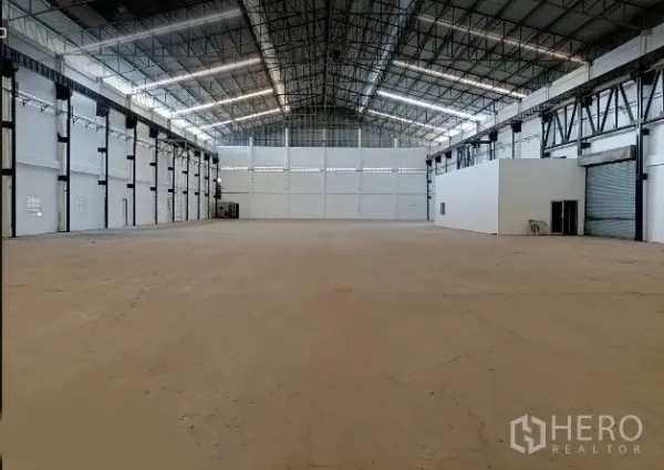 工厂 出租在Bang Phli, Samut Prakan - 宽敞工厂内部，高挑钢结构屋顶与采光带，整片混凝土地面，侧置办公室与卷闸门，位于北榄府邦普里。