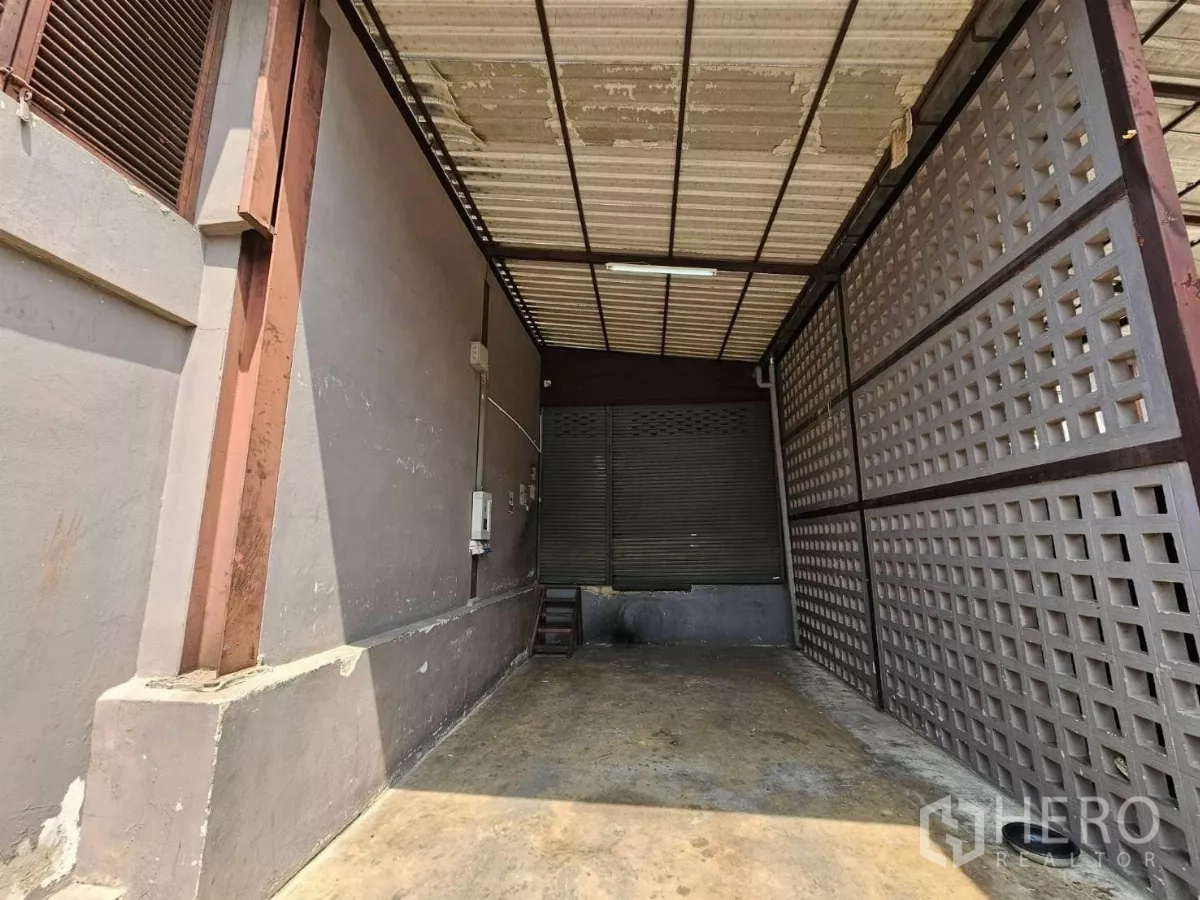 Warehouse for rent in Chatuchak, Bangkok - Covered loading dock with metal roof, ventilated block wall and roller shutter.