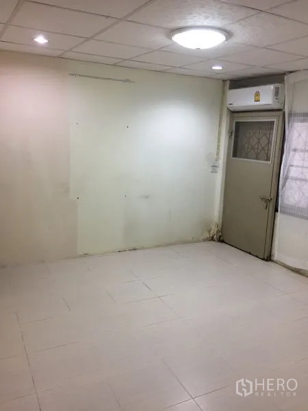 ทาวน์เฮาส์ ให้เช่าในKhlong Toei, Bangkok - ห้องปูกระเบื้องโล่ง มีประตูออกระเบียงเล็กและเครื่องปรับอากาศ