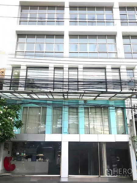 Office Space for rent in Bang Kapi, Bangkok - Multi-storey commercial building exterior with large grid windows and a glass-fronted ground floor.