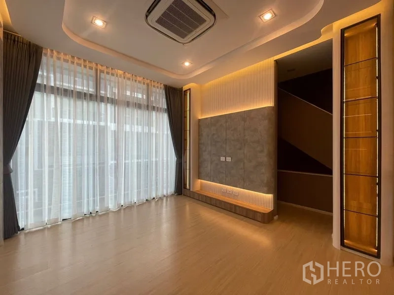 Townhouse for sale - Bright living area with floor‑to‑ceiling curtains, a feature wall and recessed lighting.