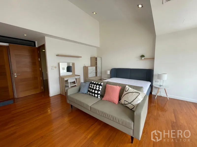 Townhouse for rent in Khlong Toei, Bangkok - Master suite view featuring bed, sofa and dressing table on timber floors.