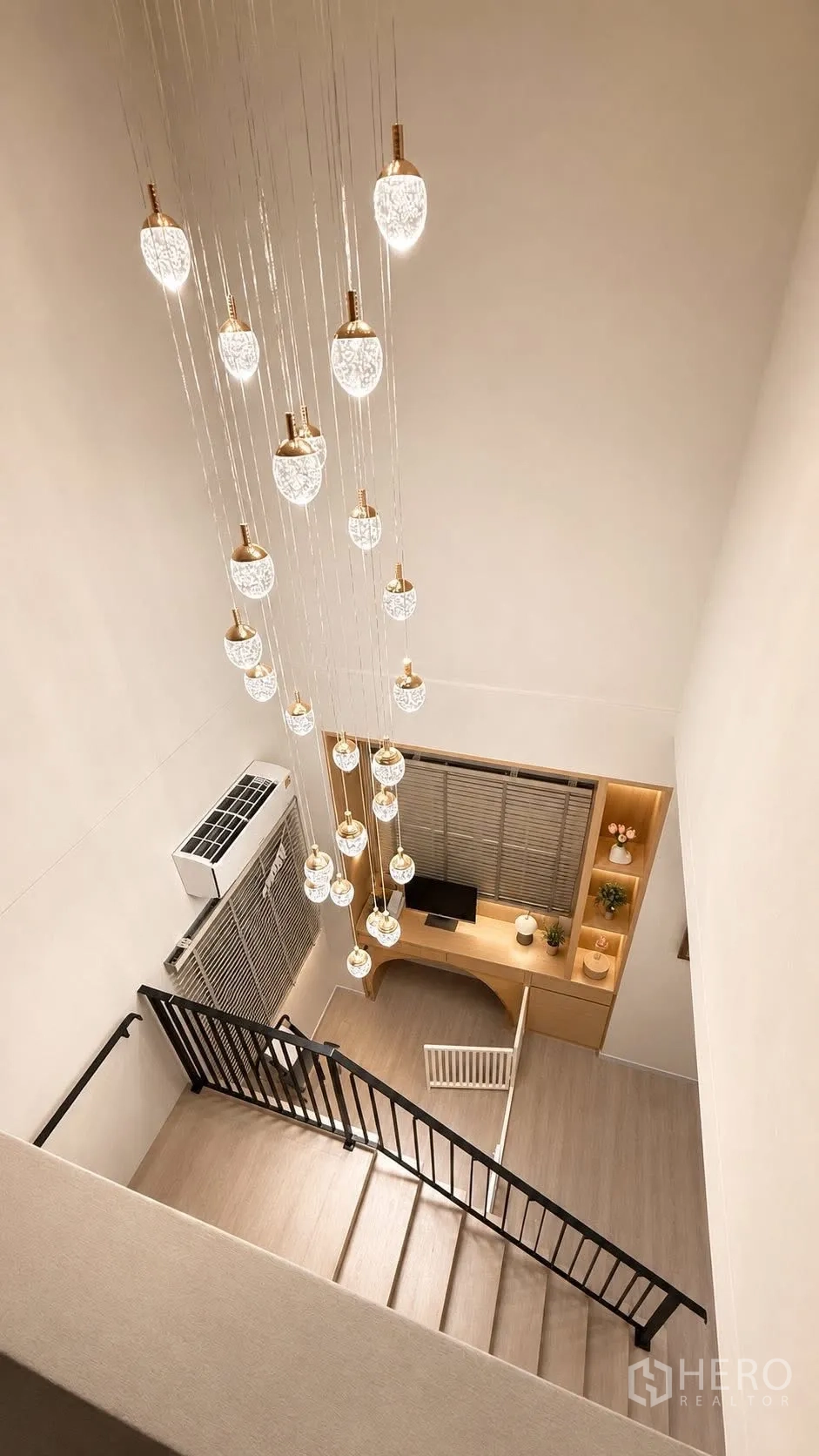 Detached House for rent or sale in Bang Phli, Samut Prakan - Staircase with a dramatic multi-pendant chandelier and a built-in study desk below.