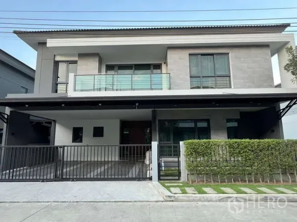 Detached House for rent in Bang Phli, Samut Prakan - Street view of the home’s modern front elevation and manicured hedge.