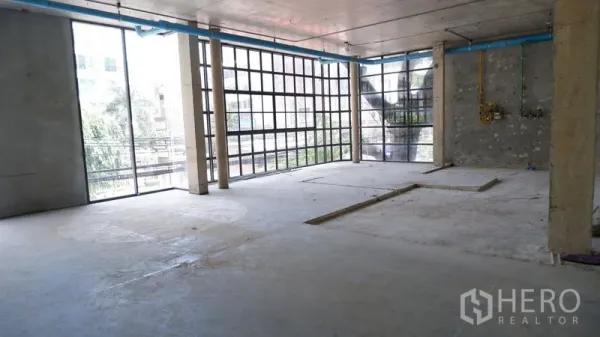 零售空间 出租在Watthana, Bangkok - 曼谷瓦塔那开放式零售毛坯，双面落地网格窗与外露混凝土天花，临街绿景。