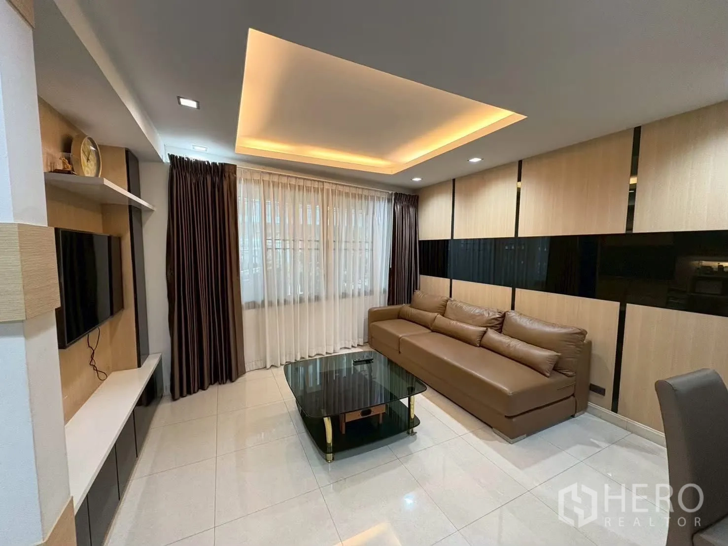 联排别墅 for rent in Pathum Wan, Bangkok - 起居区设电视柜、大窗与长沙发。