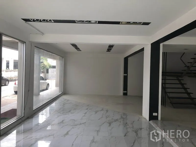 零售空间 出租在Watthana, Bangkok - 明亮拐角商铺，落地窗与高光大理石纹地面。