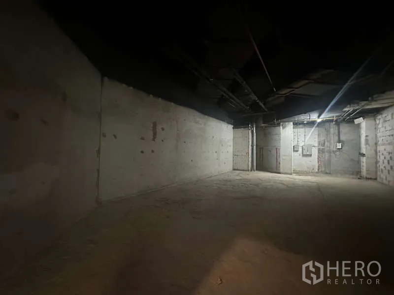 零售空间 出租 - 狭长型空置房间，裸露混凝土与天花设备一览，便于零售铺面装潢。