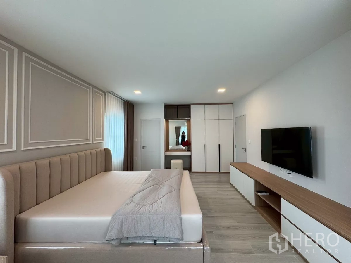 Detached House for rent in Bang Phli, Samut Prakan - Spacious master bedroom with upholstered bed, TV console and wardrobe cabinetry