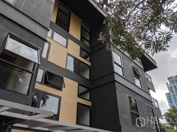 办公空间 出租在Phaya Thai, Bangkok - 低层现代建筑外观，黑色与黄色砖立面，配可开启窗