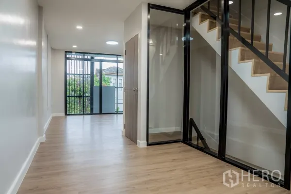 ทาวน์เฮาส์ ขายในWatthana, Bangkok - พื้นที่พักผ่อนชั้นบน กั้นบันไดด้วยกระจก และประตูกระจกบานเลื่อนเปิดสู่ระเบียง