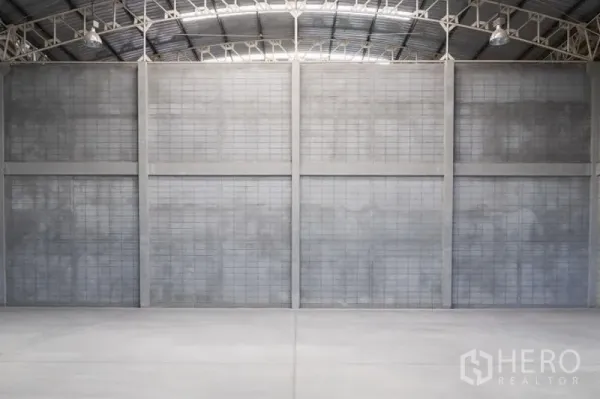 工厂 出租在Mueang Samut Sakhon, Samut Sakhon - 宽阔的仓库内部，高挑混凝土隔墙与平整工业地面