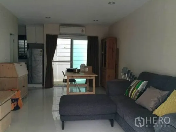 ทาวน์เฮาส์ ขายในSuan Luang, Bangkok - โถงรับแขกและรับประทานอาหารแบบโอเพนพร้อมโซฟา โต๊ะ และประตูบานเลื่อนกระจก