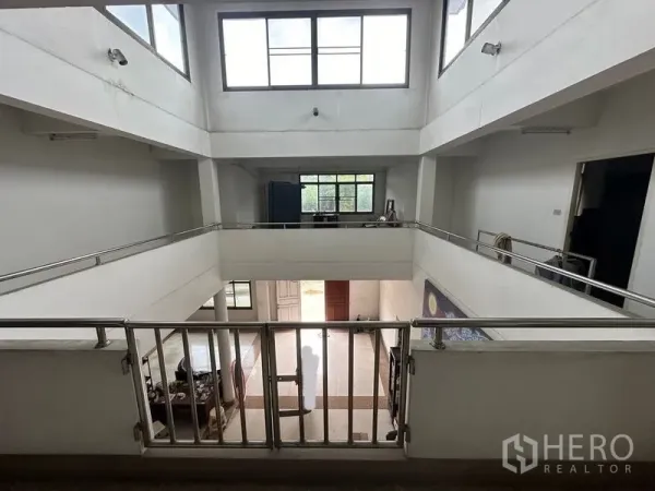 Home Office for sale in Phra Pradaeng, Samut Prakan - Central atrium with open mezzanine walkways and metal railings.