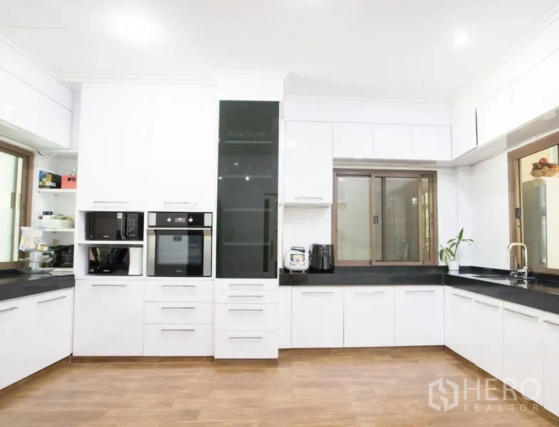 บ้าน ขายในLat Krabang, Bangkok - ครัวยูรูปโทนขาว เคาน์เตอร์หิน ตู้เก็บของเยอะ เตาอบบิวท์อิน ไมโครเวฟ และหน้าต่างใหญ่