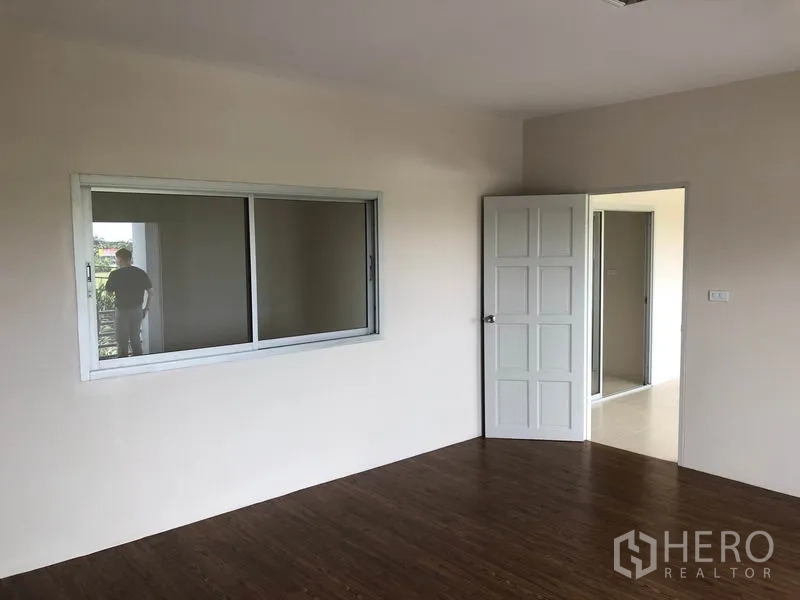 工厂 出租在Pak Kret, Nonthaburi - 二楼办公室，设窗户、木纹地板与白色门。